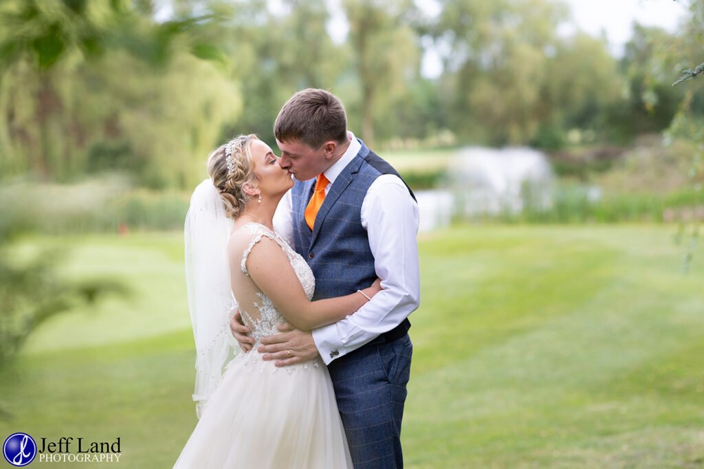 Romantic Bridal portrait kiss by the lake at the Vale Golf Club Evesham