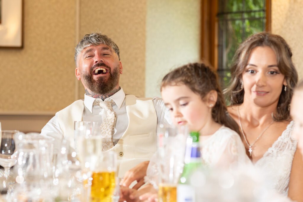 Cedar Room wedding reception groom laughing during speeches approved Wedding Photographer Alveston Manor Stratford upon Avon