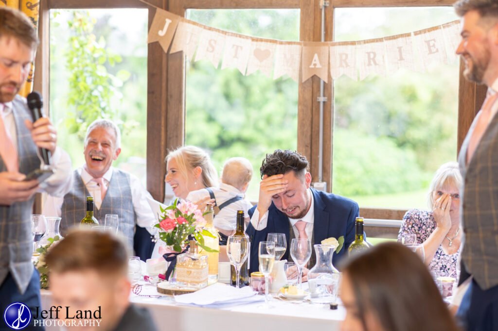 Wedding Reception at Alveston Pastures Farm Stratford upon Avon, Warwickshire best man speech groom with hand on head