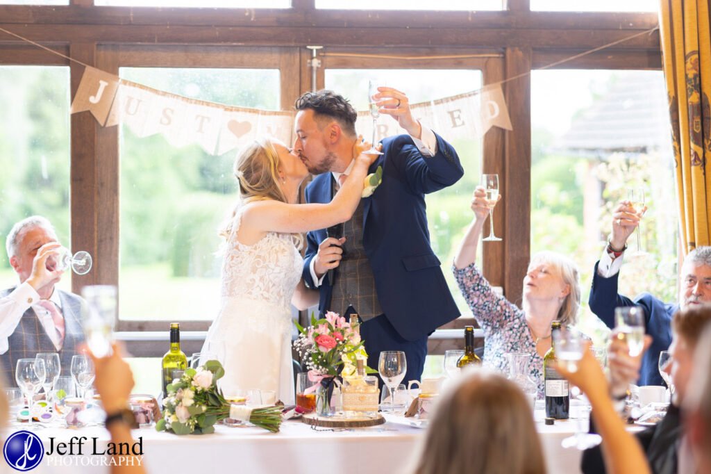 Wedding Reception at Alveston Pastures Farm Stratford upon Avon, Warwickshire bride and groom kiss top table