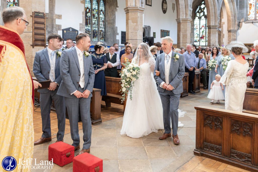 Bride Walking down the aisle with Dad first look at Groom Holy Trinity Church Wedding Stratford upon Avon